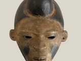 an image of a wooden mask with a black hat on it