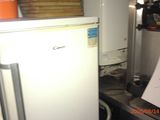 a white refrigerator in a kitchen with a lot of clutter on it