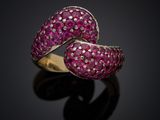 a close up view of a pink sapphire and diamond bypass ring