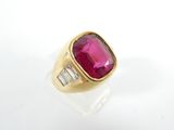 un gros plan d'une bague en or sertie d'un rubis et de diamants taille baguette