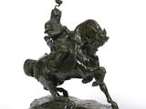 bronze statue of a man on a horse with a bird on its back