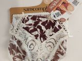 une culotte marron et blanche suspendue à un cintre posé sur une table