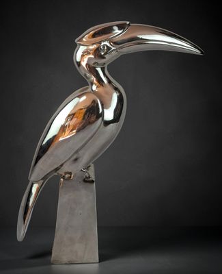 a close up of a metal bird statue on a pedestal