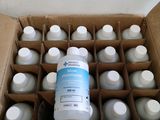a cardboard box filled with bottles of water and a bottle of liquid