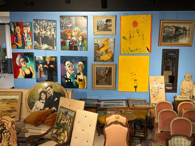 une pièce remplie de nombreux tableaux et de chaises