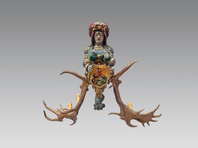 une statue représentant une femme assise sur les bois d'un cerf