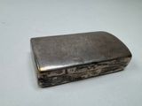 an old silver cigarette case sitting on top of a white table