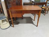 un bureau en bois avec des tiroirs et une chaise dans une pièce