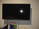 a flat screen tv mounted on a wall above a desk