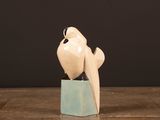 a white bird sitting on top of a wooden block