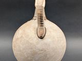 a white vase with a brown handle sitting on a table