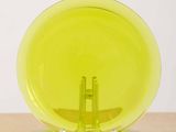 a yellow glass object on a plate on a table