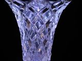 a glass vase that is sitting on a black surface
