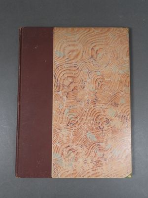 an old book sitting on a table with a brown cover
