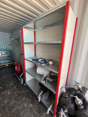 un local de stockage équipé de nombreuses étagères et d'une borne d'incendie