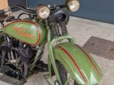 a green motorcycle that is parked in front of a building