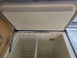an open refrigerator with a basket inside of it