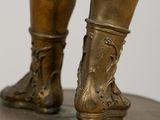 bronze statue of a man standing on a pedestal with his foot on the ground