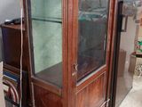 un meuble en bois avec une porte en verre au milieu d'une pièce