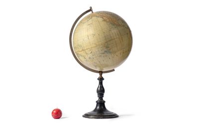 un petit globe et une boule rouge posés sur une surface blanche