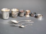 a lot of silver spoons and cups on the table