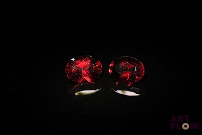 une paire de boucles d'oreilles à clous en verre rouge sur fond noir