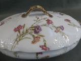 a white plate with flowers on it and a gold handle