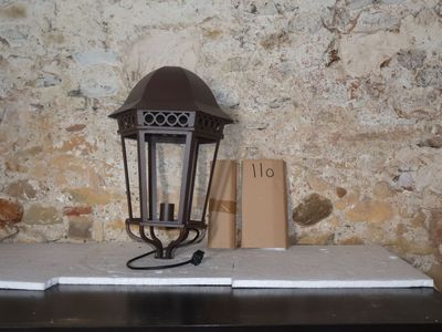 une lampe posée sur une table devant un mur de briques