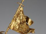 gold figurine of a man holding a flag on a horse