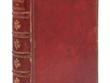 un vieux livre rouge avec des bordures dorées sur la couverture