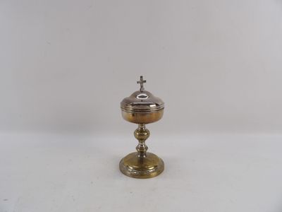 une petite assiette en argent surmontée d'une croix