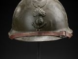an old helmet on a metal stand with a black background