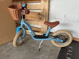 a small blue bike with a basket on the back of it
