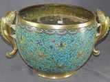un grand vase bleu avec une anse dorée sur fond gris