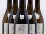 six bottles of wine are lined up in a row on a white surface