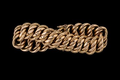 gros plan d'un bracelet en or sur fond noir