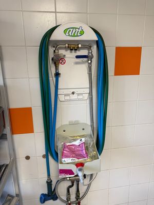 a toilet with a hose attached to it in a bathroom