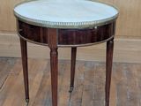 une petite table avec un plateau en marbre sur un plancher en bois
