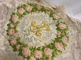 un oreiller blanc orné de roses roses, posé sur un lit