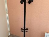 un porte-manteaux noir avec une tringle à vêtements, placé dans un coin de la pièce