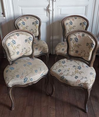 four chairs that are sitting on a wooden floor