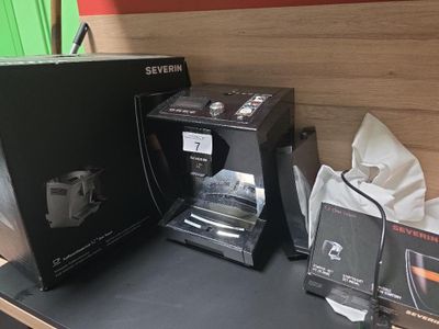 une cafetière posée sur un plan de travail, à côté d'une boîte de café