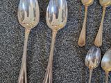 six silver spoons and two silver spoons sitting on a table