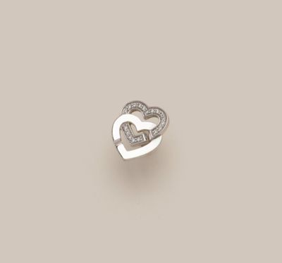 une bague en diamant en forme de cœur ouverte sur un fond beige