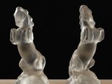 two clear glass sculptures of a dog and a cat on a table