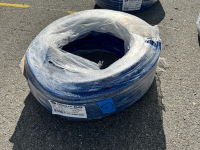 deux rouleaux de tuyaux bleus posés par terre