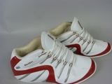 une paire de baskets rouges et blanches posées sur une surface blanche