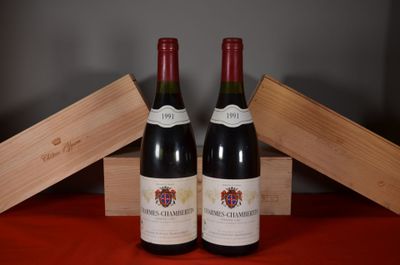 two bottles of red wine sitting next to each other on a table