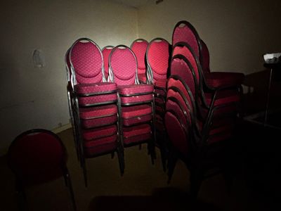 beaucoup de chaises rouges dans une pièce où la lumière est allumée