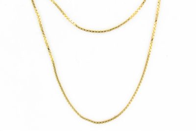 un collier en or avec une chaîne sur fond blanc